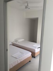 two beds in a room with a mirror at Hermosa casa vacacional in Suárez
