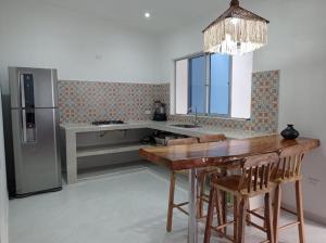 a kitchen with a wooden table and a refrigerator at Hermosa casa vacacional in Suárez