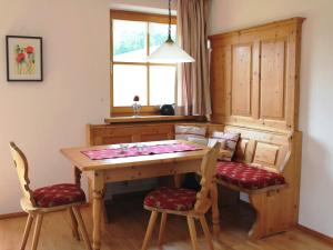 a kitchen with a wooden table and two chairs at Schmuckhäusl in Reit im Winkl