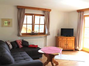 a living room with a couch and a tv at Schmuckhäusl in Reit im Winkl +13 photos