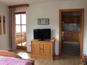 a living room with a television on a wooden cabinet at Schmuckhäusl in Reit im Winkl