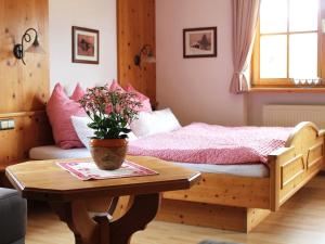ein Schlafzimmer mit einem Bett und einem Tisch mit einer Topfpflanze in der Unterkunft Schmuckhäusl in Reit im Winkl
