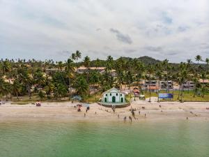 a group of people on a beach near the water at FLAT PRAIA DOS CARNEIROS - Eco Resort Praia dos Carneiros ao lado da Igrejinha in Rio Formoso