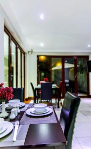 uma sala de jantar com uma mesa e cadeiras, uma mesa e uma espreguiçadeira em The Pillows Suite em Pretoria