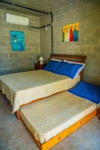 two beds in a room with a wall at Casa do Pescador Camburi in Camburi