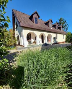 a large white house with a brown roof at Edelmann Panzió in Balatonakali