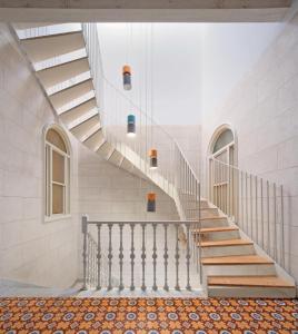 una escalera en un edificio con paredes y techos blancos en Hotel Hevresac Singular & Small en Mahón