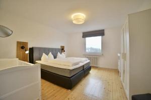 Villa Heidi في برونلاغ: غرفة نوم بسرير ونافذة كبيرة