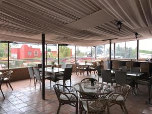 a restaurant with tables and chairs and windows at Casa de las Escaleras in Pátzcuaro