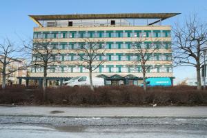 Un coche blanco aparcado delante de un edificio en Good Morning Sollentuna, en Sollentuna