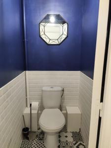 a bathroom with a white toilet and a blue wall at Superbe Duplex en plein cœur de Crépy-en-Valois in Crépy-en-Valois