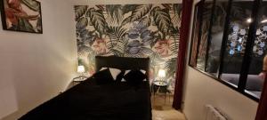 1 dormitorio con 1 cama negra y 2 lámparas en LE PATIO / les suites romantiques du grenier à sel, en Honfleur