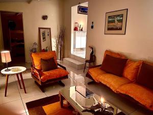 - un salon avec un canapé orange et une chaise dans l'établissement sitio santa Eulalia, à Cunha