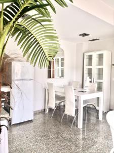 une salle à manger avec une table et des chaises blanches dans l'établissement SeaHomes Vacations, BEACH&POOL, in Fenals Beach, à Lloret de Mar