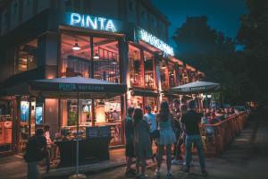 a group of people standing outside a restaurant at night at Hotel Chmielna Warsaw in Warsaw