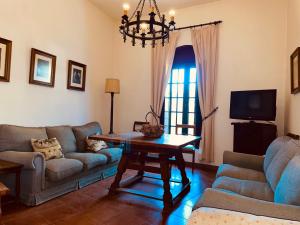 - un salon avec un canapé et une table dans l'établissement Casa Rural Finca de las Encarnaciones Bajas, à Villanueva de San Juan