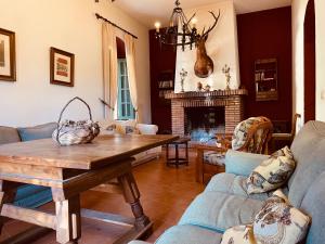 - un salon avec une table et une cheminée dans l'établissement Casa Rural Finca de las Encarnaciones Bajas, à Villanueva de San Juan