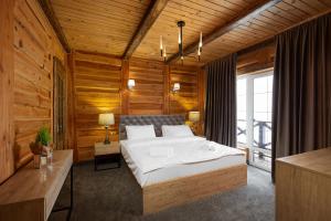 - une chambre avec un grand lit et des murs en bois dans l'établissement SVOI Hotel, à Palyanytsya