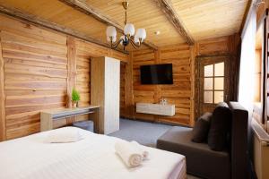 - une chambre avec un lit, un canapé et une télévision dans l'établissement SVOI Hotel, à Palyanytsya