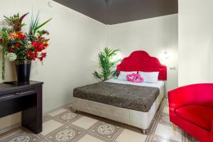 Ashamba Guest House في غولوبايا بوختا: غرفة نوم بسرير احمر وكرسي احمر