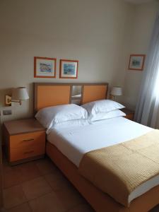 a bedroom with a large bed and two night stands at Ale's residence in Casal Palocco