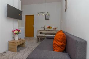 a living room with a gray couch with an orange pillow at Villa Vita Apartments in Crikvenica