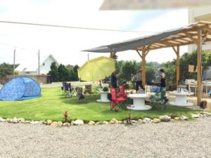 een picknickplaats met tafels en tenten op een gazon bij Ashibidoro Trailer camp - Vacation STAY 96487v in Akaoki