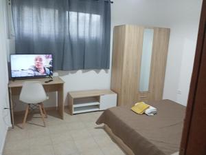 a bedroom with a bed and a desk with a television at One Bedroom Flat 250m from Sea, Nea Chili in Alexandroupoli