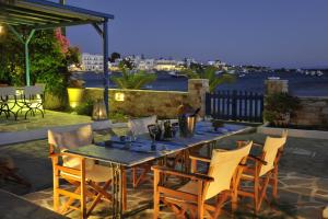a table and chairs on a patio with a view of the water at George's beach studios Aliki Paros in Aliki