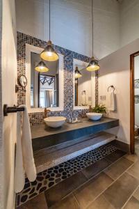 une salle de bain avec deux lavabos et deux miroirs dans l'établissement Casa Jacaranda Hotel Boutique by HMC -Cauca Viejo- Mayores de 14 años, à Jericó