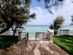 a gate to the beach with the ocean in the background at Aurelia Sea View in Torre Canne