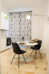 a dining room with a table and two chairs at POSA - Charming Rooms in Acquaviva delle Fonti