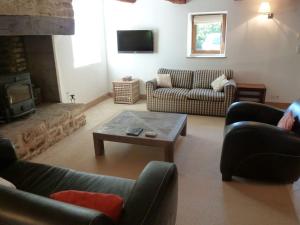 a living room with two couches and a fireplace at Spacious Longere,heated swimming pool, idyllic setting, Southern Brittany, FR in Pluherlin