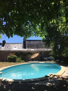 a large blue swimming pool in front of a building at Spacious Longere,heated swimming pool, idyllic setting, Southern Brittany, FR in Pluherlin