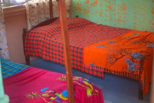 a bedroom with two bunk beds and a blanket at Kabatoro Guest House in Kabatoro