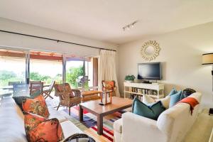 a living room with a couch and a table at Beach House Plett Lookout in Plettenberg Bay