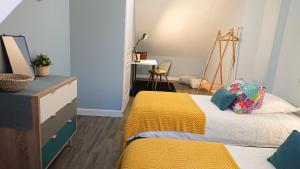 - une chambre avec un lit et une couverture jaune dans l'établissement Maison Cosy La Jolie Fécampoise, à Fécamp