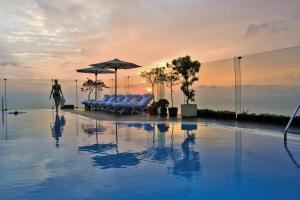 una piscina con sedie e ombrelloni in cima a un edificio di Miraflores Park, A Belmond Hotel, Lima a Lima