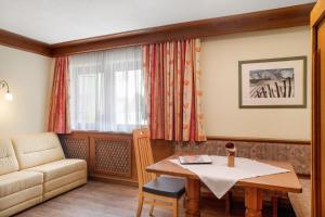 a living room with a table and a couch at Appartements Kardona in Ischgl