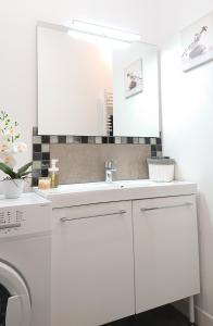 a white bathroom with a sink and a washing machine at Maison Cosy La Jolie Fécampoise in Fécamp