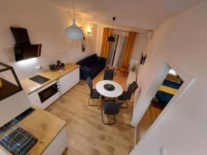 ein kleines Wohnzimmer mit einem Tisch und einer Küche in der Unterkunft Allewidok in Jelenia Góra