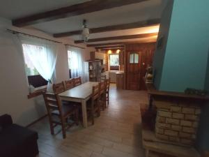 a kitchen and dining room with a table and chairs at domek nad jeziorem in Kujan