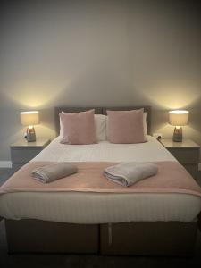 a bed with two pillows and two lamps on it at Seaview Luxury Apartments in Redcar