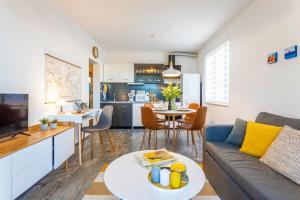 a living room and kitchen with a couch and a table at Apartman Olive in Supetar