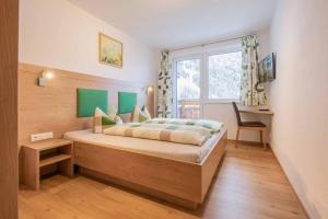 Schlafzimmer mit einem Bett, einem Fenster und einem Schreibtisch in der Unterkunft Fuchs & Hase in Gasteig