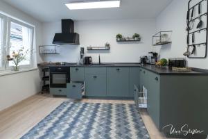 a kitchen with blue cabinets and a black counter top at Sali Homes - Bergerie in Obersulm
