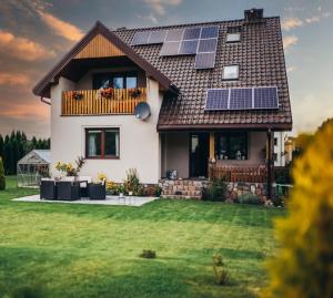 a house with solar panels on the roof at Apartament Spokojna 7 Gołdap Mazurski Zdrój in Gołdap