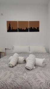 dos pilas de toallas sentadas en una cama en Guimar New Style, tu nueva elección, en Córdoba