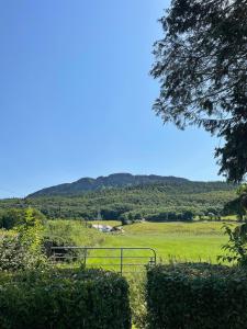 ein Feld mit einem Zaun und Bergen im Hintergrund in der Unterkunft Milltown Cottage in Aghanloo + 18 Fotos