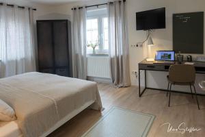 a bedroom with a bed and a desk with a computer at Sali Homes - Bergerie in Obersulm +44 photos